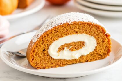 رول كعكة يقطين فاخرة محشوة بكريمة جبنة غنية ومزيّنة بالقرفة